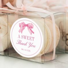 some cookies in a clear box with a pink bow on it's ribbon and thank you tag