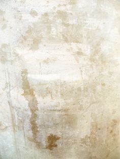 an old white wall with some rust on it