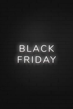 the words black friday are lit up against a dark brick wall with white neon lights