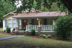 a small white house sitting in the middle of a yard