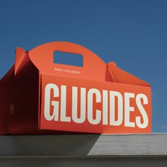 an orange box with the word gluddles on it sitting on top of a building