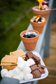 there are several small pots with marshmallows on the table next to each other