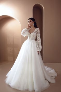 a woman in a white wedding dress standing next to an arch with light coming through it