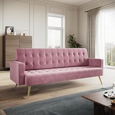 a pink couch sitting in front of a window