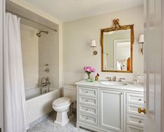 a bathroom with a sink, toilet and bathtub next to a shower curtain that has pink flowers on it