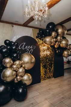 black and gold balloons are on display in the room