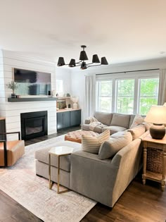 a living room filled with furniture and a flat screen tv mounted on the wall above a fire place