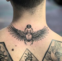 a man's back with tattoos on his chest and wings above the scarp