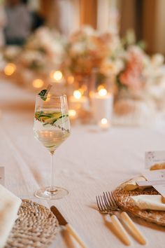 there is a glass of wine on the table with silverware and utensils