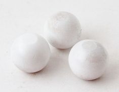 three white balls sitting on top of a table