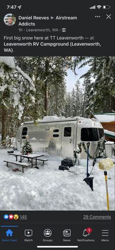 an rv parked in the snow next to a picnic table