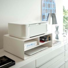 a white printer sitting on top of a shelf