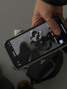 a person holding up a cell phone in their left hand, with the image on it's screen