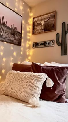 a white bed topped with lots of pillows next to a wall covered in string lights