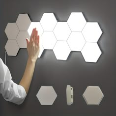 a woman is touching the wall with her hand and several lights on top of it