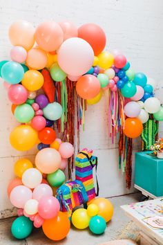 colorful balloons and streamers are hanging from the wall in this kids's room