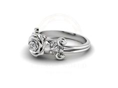 a white gold engagement ring with two roses on the side and a diamond in the middle