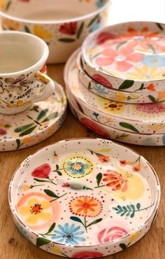 colorful floral plates and cups on a wooden table