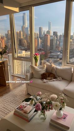 a living room filled with furniture and a large window covered in lots of windows overlooking the city