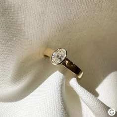 a diamond ring sitting on top of a white cloth