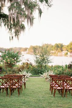 there are many chairs in the grass near each other and one is set up for an outdoor ceremony