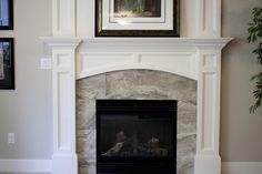 a living room with a fire place and pictures on the wall above it's mantle