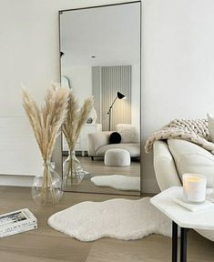 a living room filled with furniture and a large mirror on the wall next to a white couch