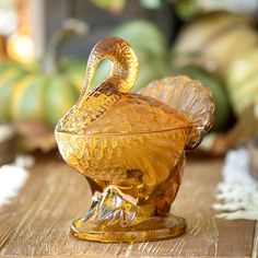 a glass bird sitting on top of a wooden table