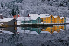 the houses are all covered in snow by the water's edge, and there is no image to describe