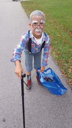 an old man with glasses and a cane is on the sidewalk next to a blue bag