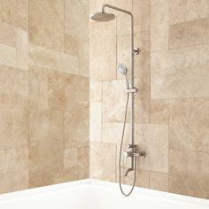 a bathtub with a shower head and handset in a tiled wall bathroom area