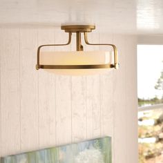 a light fixture hanging from the ceiling in a room with white walls and wood paneling