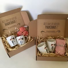 two boxes with coffee mugs in them on a table