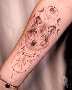 a woman's arm with a tattoo on it and a wolf in the middle