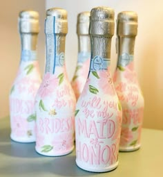 three small bottles that are sitting on a table with the words bridesmaid and maid of honor painted on them