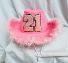 a pink hat with the number twenty two on it sitting on top of a white sheet