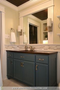 a bathroom with blue cabinets and white walls