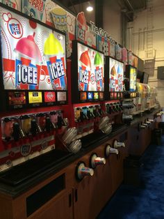 a row of vending machines sitting on top of a blue carpeted floor next to each other