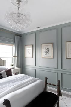 a bedroom with blue walls and white bedding