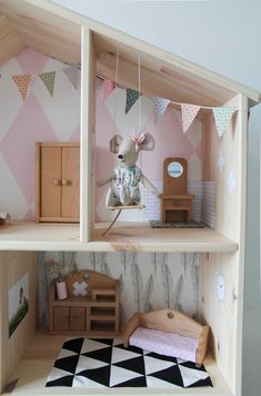 a doll house with a mouse on the top shelf