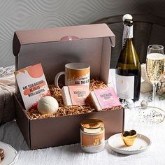 an open box filled with different types of food and drinks on top of a table