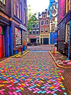 an empty street is decorated with multicolored tiles and words that read amsterdam is pretty awesome