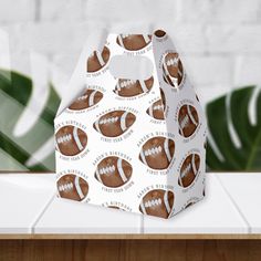 a brown and white paper bag with footballs on it