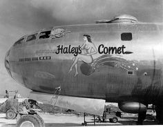 an old photo of a woman sitting on the nose of a large airplane that says haleys comet