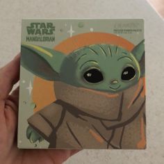 someone holding up a card with an image of the child yoda from star wars