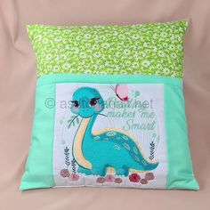 a pillow with an embroidered dinosaur on it