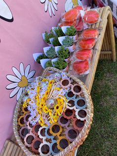 an assortment of sunglasses and sushi on display in a basket next to a pink wall