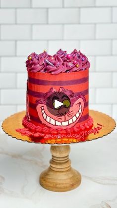 there is a cake that looks like it has been decorated with pink frosting and red icing