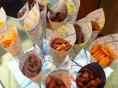 a table topped with lots of different types of food on top of plastic cups filled with sauces