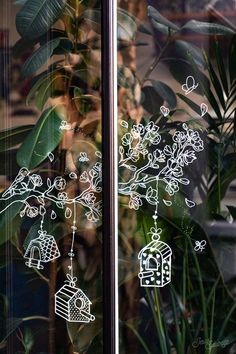 the window is decorated with birds, flowers and birdcage hanging from it's branches